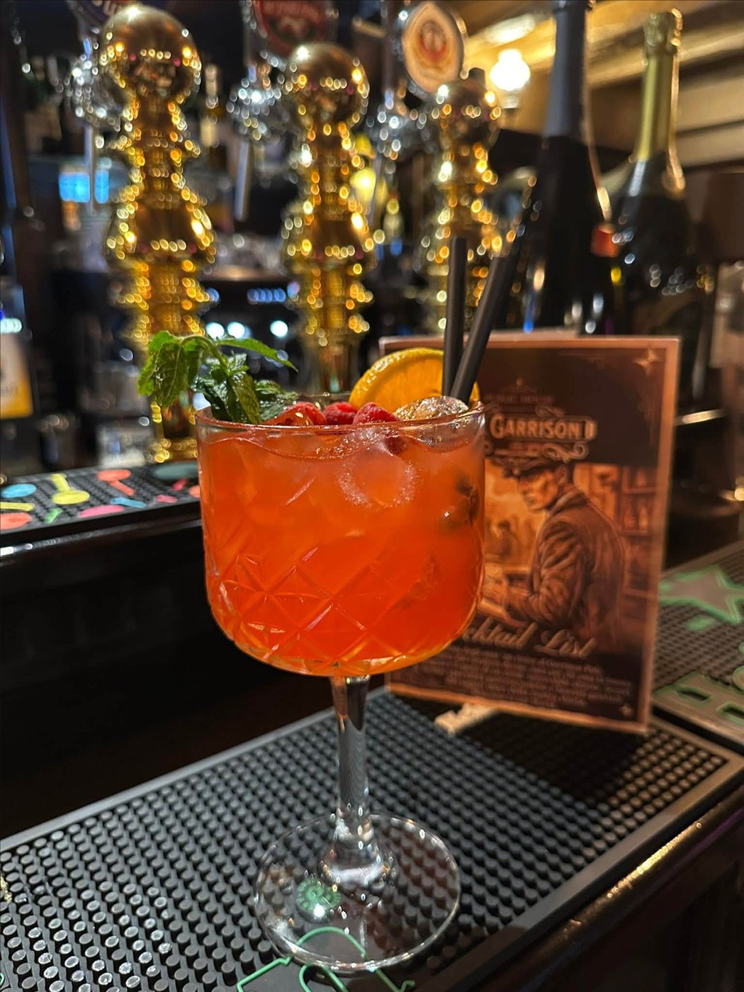 Cocktail con arancia e frutti rossi al bancone del Garrison